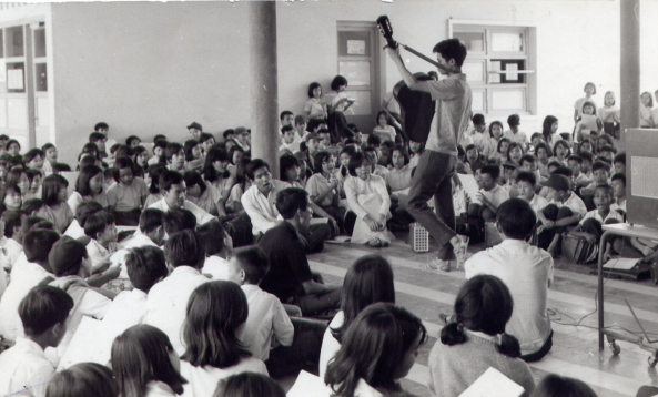 Nhạc sĩ Nguyễn Đức Quang (cầm đn) trong một buổi sinh hoạt của nhm Du Ca với cc học sinh trường Trung Học Kiểu Mẫu Thủ Đức vo cuối thập nin 1960